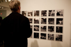 Black and white photography of audience viewing Fictive Kin gallery installation photos.